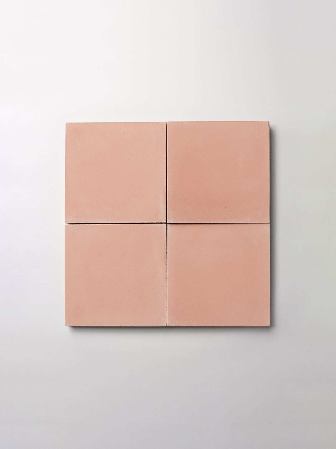 four pink square tiles on a white surface.