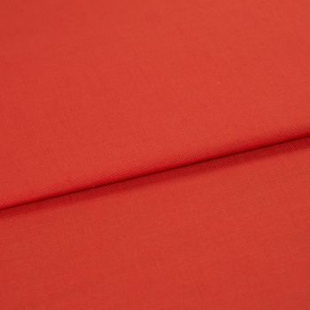 Red woven fabric panel with visible fine texture, folded across the frame forming a horizontal overlap; lying flat under soft, even studio lighting with no other objects or background details.