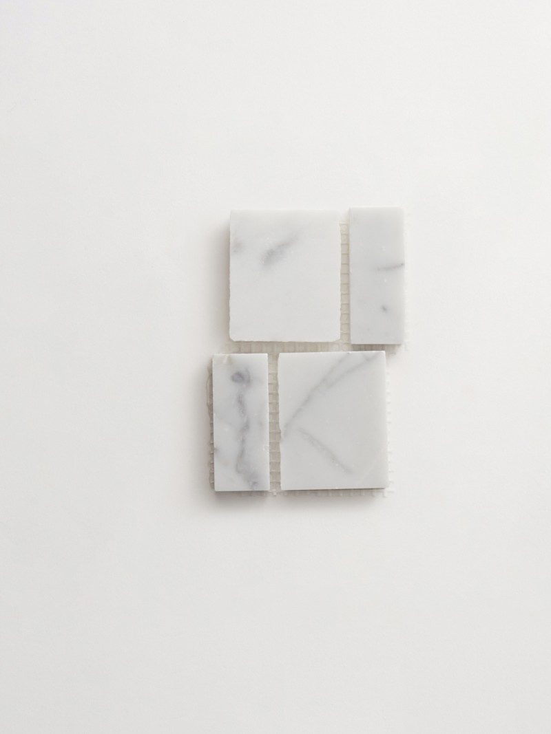 four squares of white marble on a white surface.