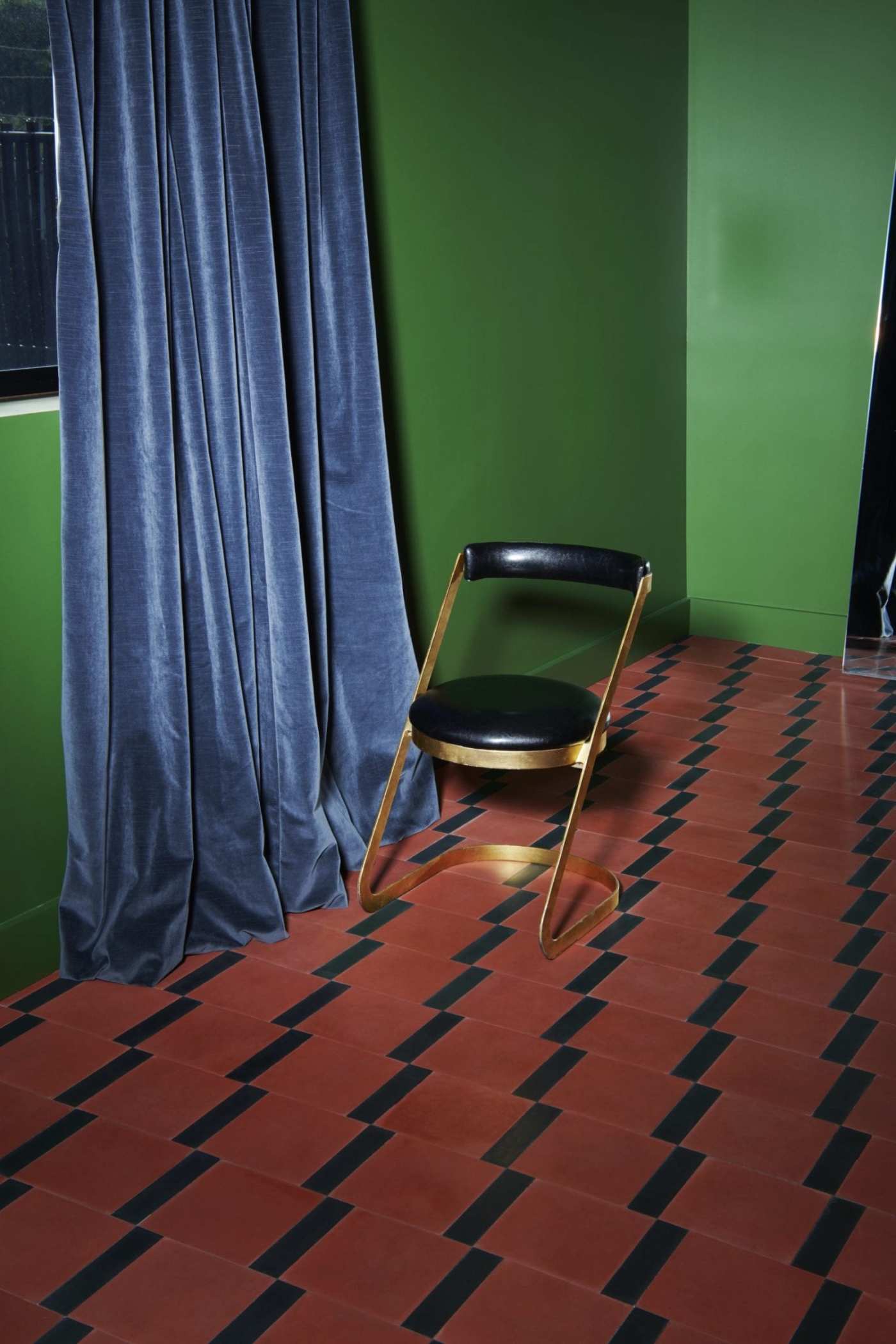 a chair sits on a red and black tiled floor.