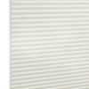 White cellular (honeycomb) blind, fully lowered and closed, its horizontal pleats visible; gently diffusing light in a neutral interior, shown in a close-up angled view.