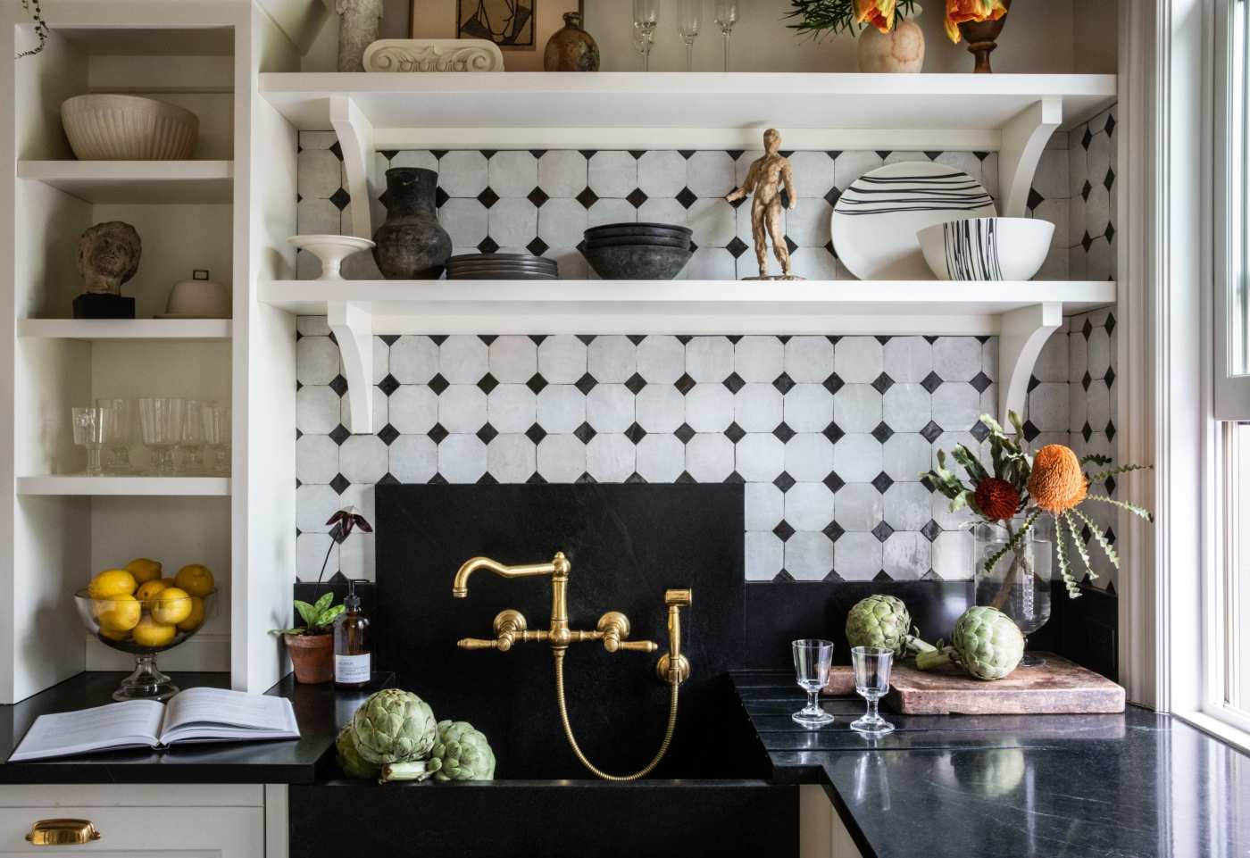 a kitchen with a black and white tile backsplash.