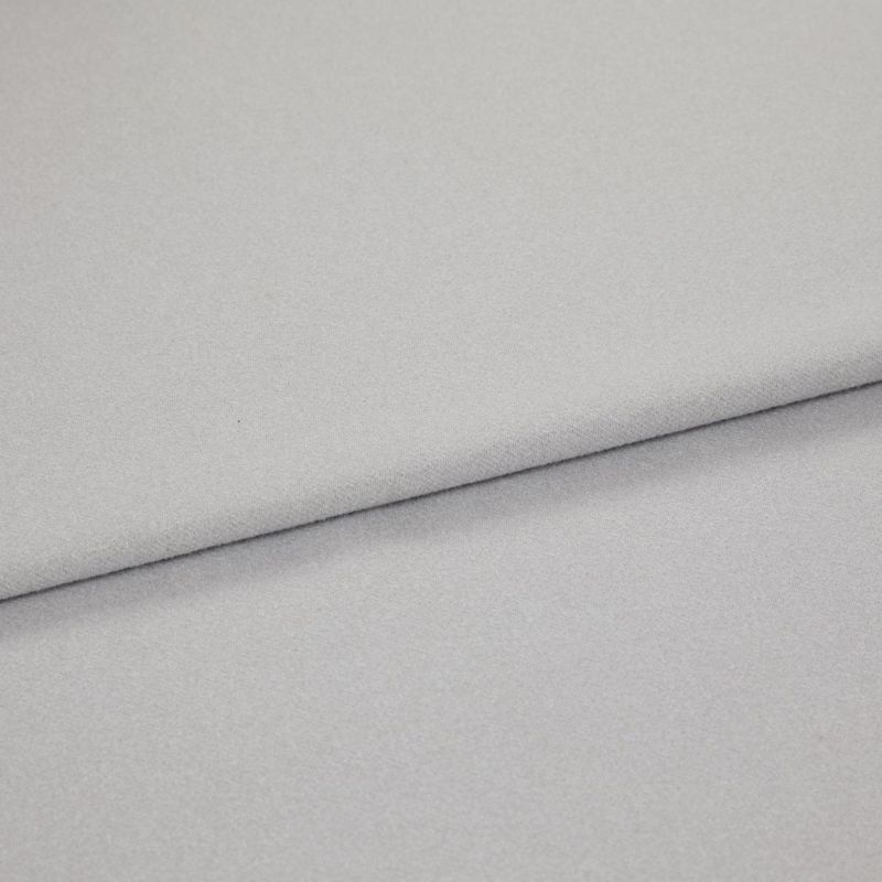 Light gray, soft-textured fabric folded diagonally across the frame, creating an overlapping edge; close-up view with diffuse, even lighting on a neutral background.