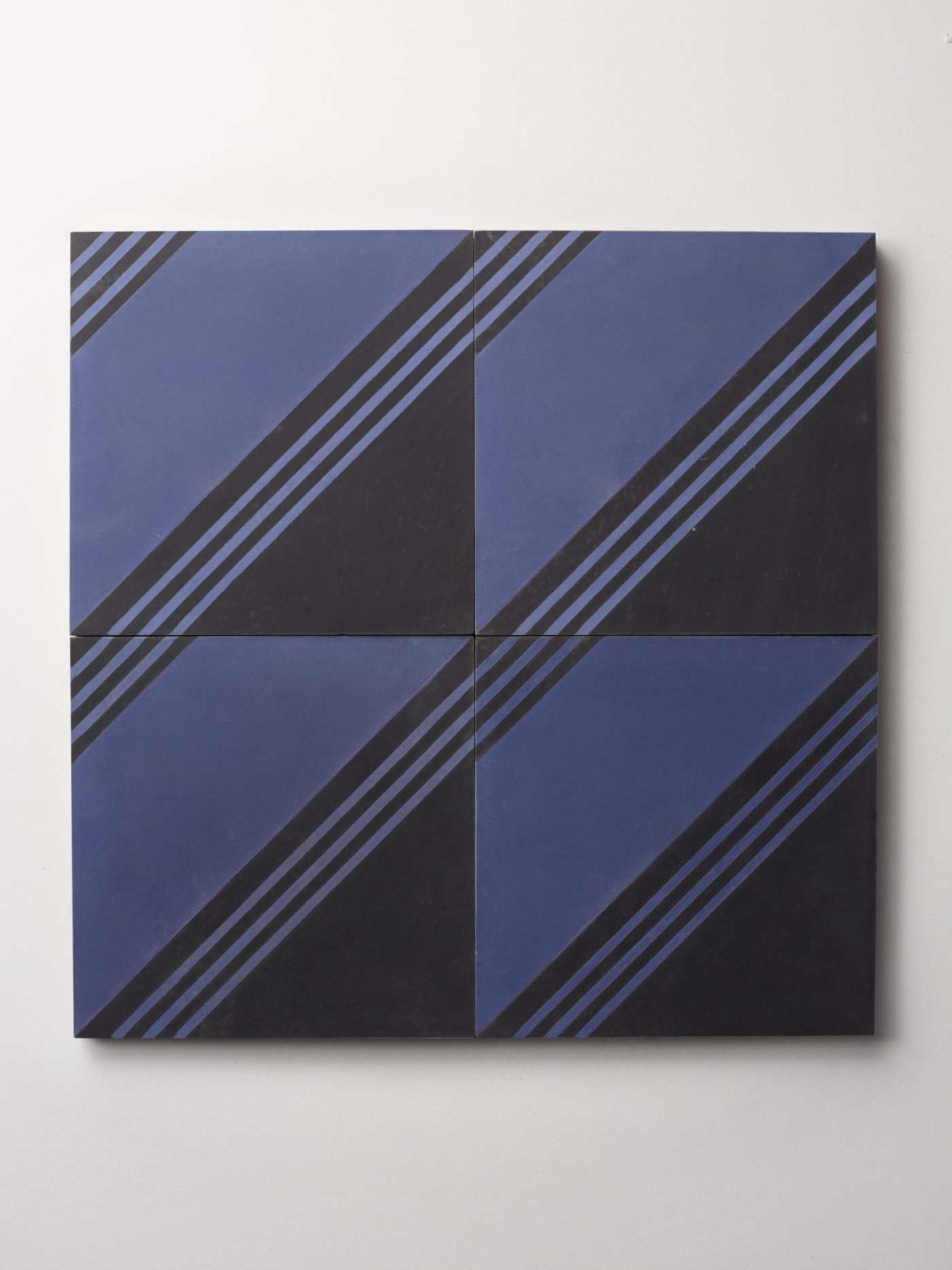 four tiles with blue and black stripes on a white background.