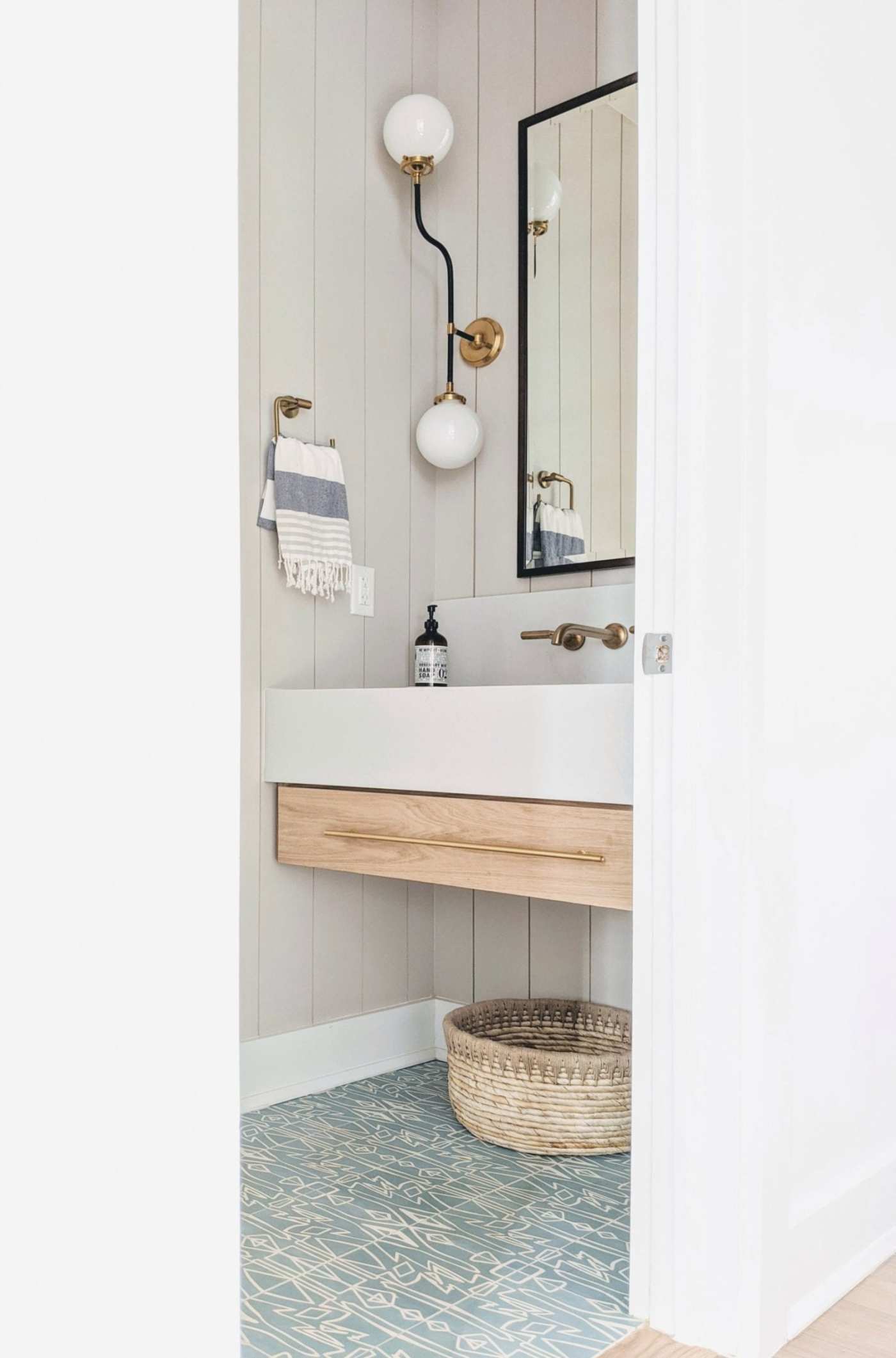 a bathroom with a blue tile floor and a wooden vanity.