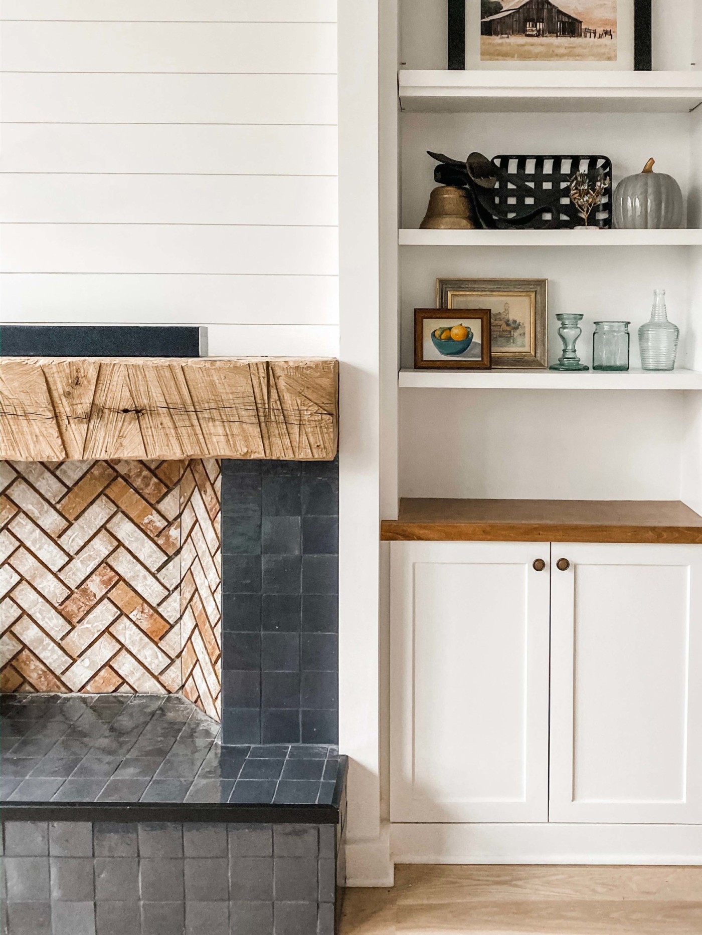 a living room with a tiled fireplace and bookshelves.