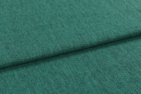 Teal-green textured upholstery fabric, close-up, showing short nap and subtle ribbing; folded horizontally with a visible overlap; photographed under soft, even lighting against an indistinct neutral background.