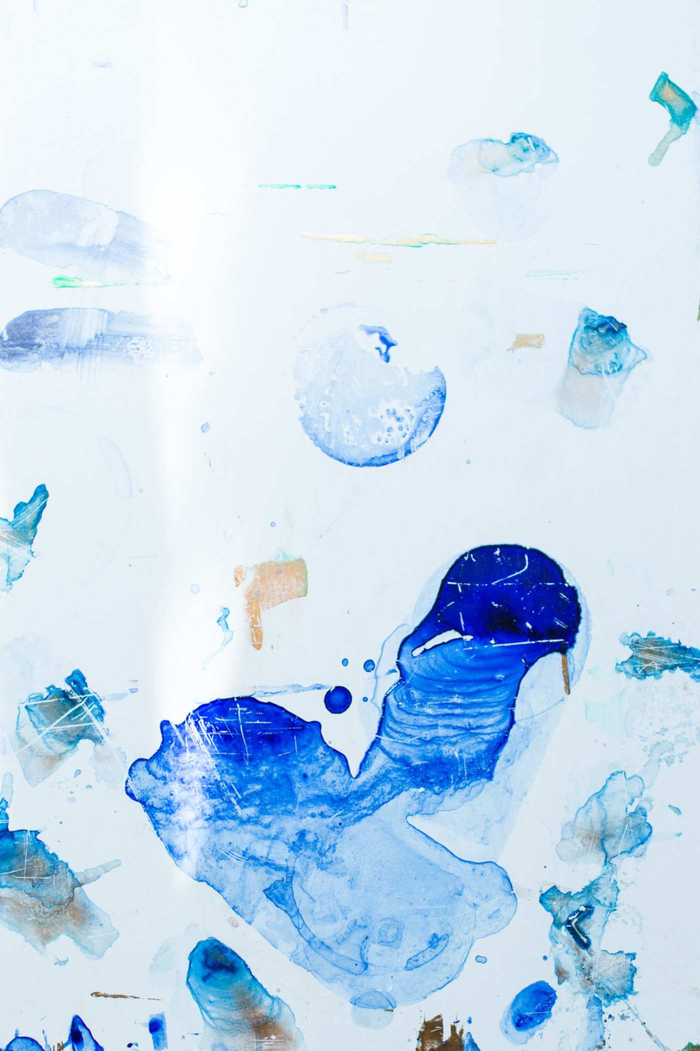 a white surface with blue and white paint splatters.