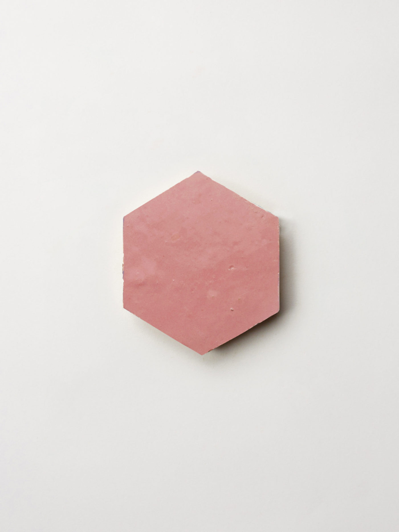 a pink hexagonal tile on a white background.