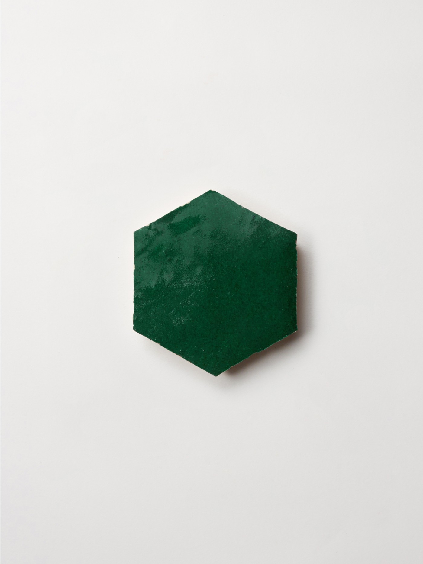 a green hexagonal tile on a white background.