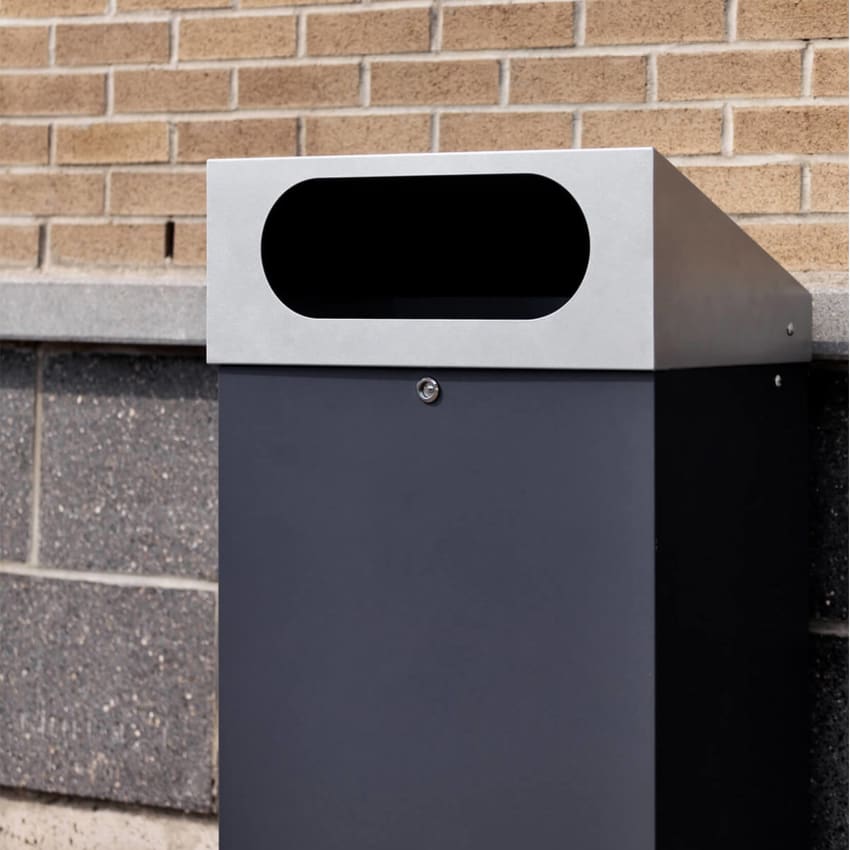 durable powder coated steel outdoor trash bin with locking lid and large waste opening outside a shopping plaza