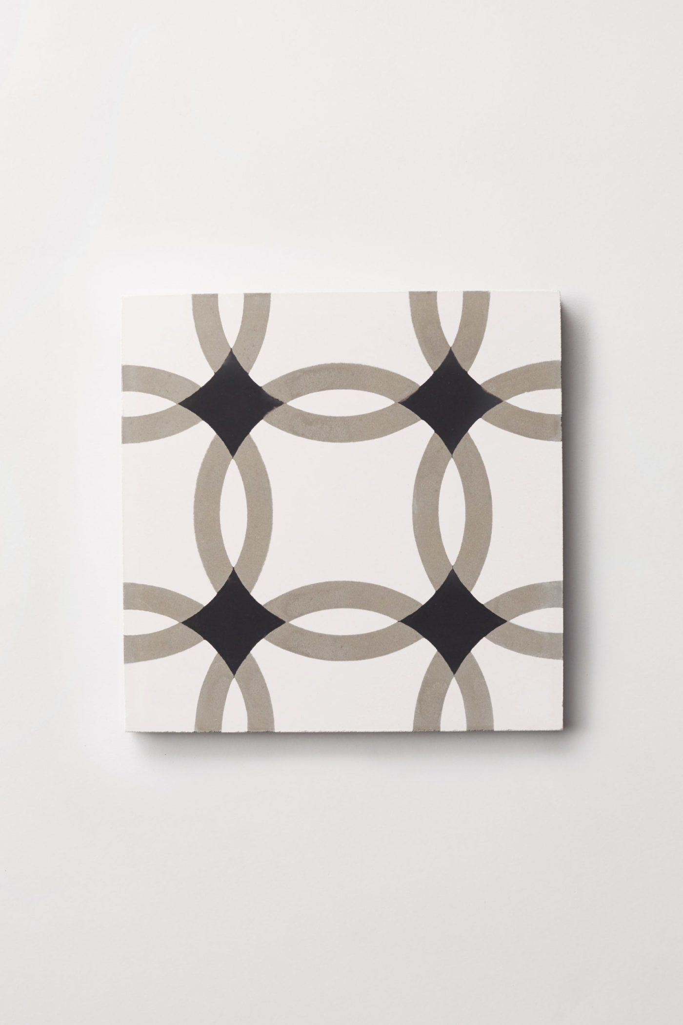 a black and white tile with an overlapping circle design on a white background.