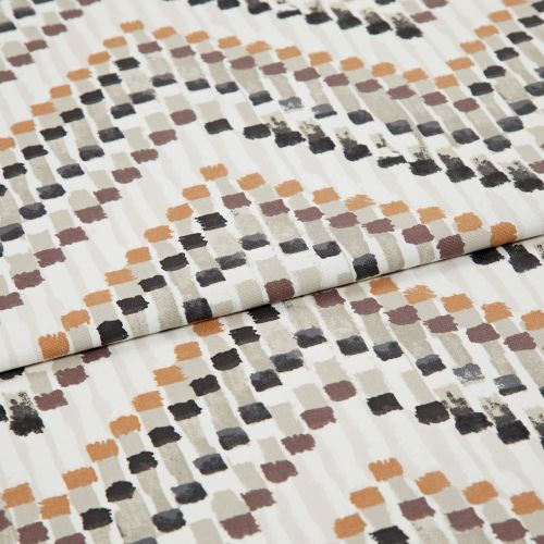 Patterned fabric swatch with staggered brushstroke square motifs in orange, brown, gray and black — folded and layered — close-up flat-lay on a neutral, evenly lit studio background.
