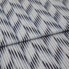 Woven cotton fabric with irregular navy and pale-blue vertical stripes, folded once across the middle; close-up view on a flat surface, evenly lit, showing texture and subtle creases.