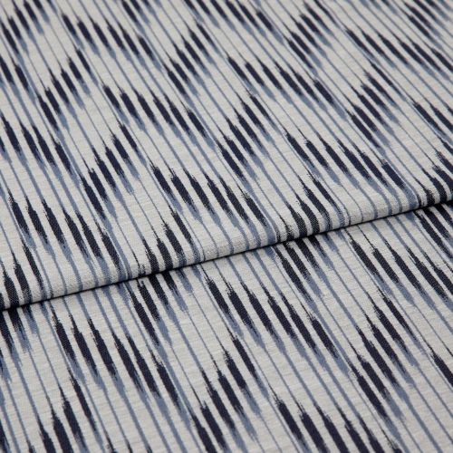 Woven cotton fabric with irregular navy and pale-blue vertical stripes, folded once across the middle; close-up view on a flat surface, evenly lit, showing texture and subtle creases.