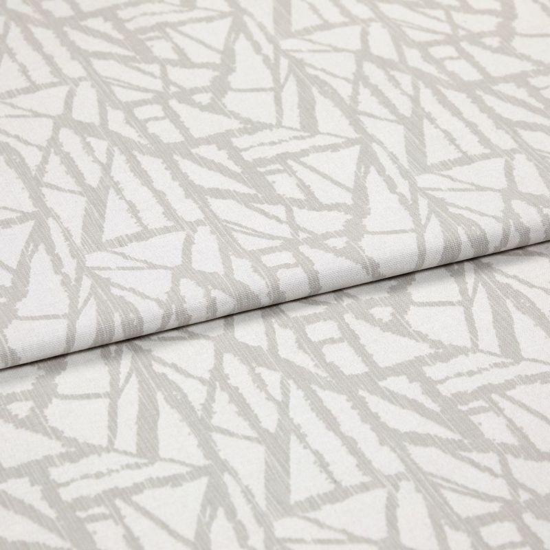 Neutral cream curtain fabric with pale grey abstract linear pattern, folded in overlapping layers; close-up studio view showing woven texture, soft even lighting and shallow depth of field.