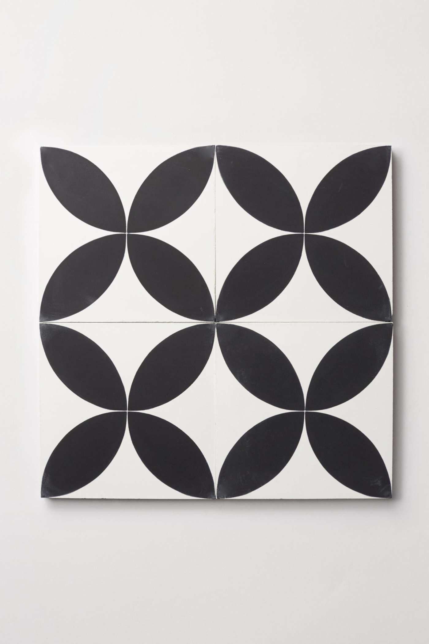 four black and white tiles forming a flower design.