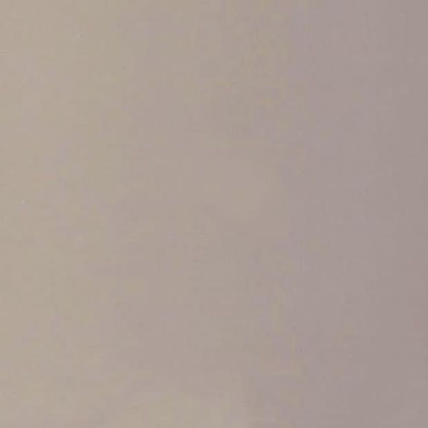 Plain light beige painted wall with subtle texture, filling the frame and evenly lit; minimal indoor setting with soft diffuse lighting and no visible fixtures or decorations.