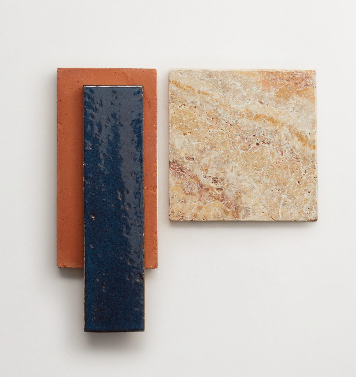 a blue, an orange, and a brown tile on a white surface.