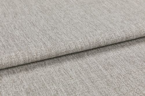 Woven light gray fabric folded in overlapping layers, showing subtle texture and flecked yarns; photographed close-up with soft, even studio lighting on a neutral surface.