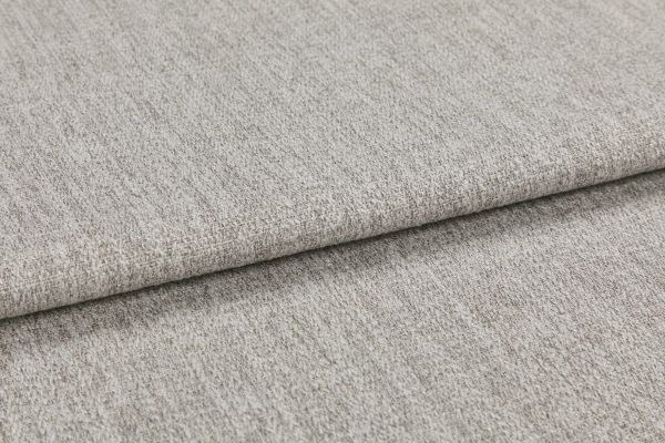 Woven light gray fabric folded in overlapping layers, showing subtle texture and flecked yarns; photographed close-up with soft, even studio lighting on a neutral surface.