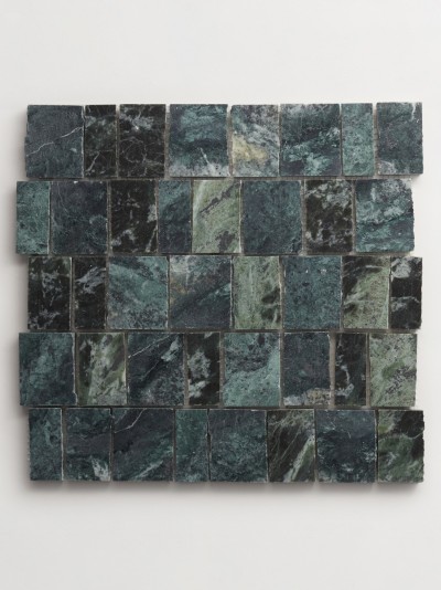 a green and black marble mosaic on a wall.