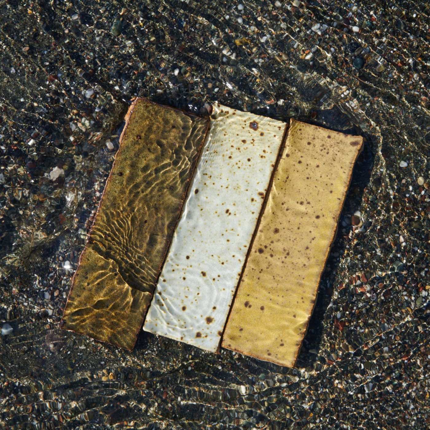 a brown, yellow, and white rectangle tile laying in the water.