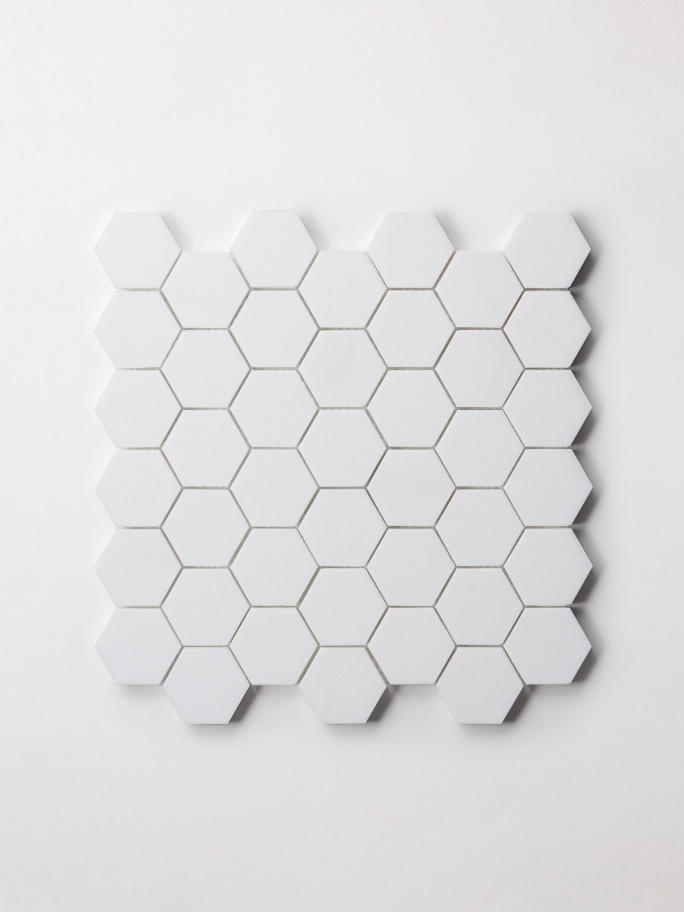 a sheet of small white hexagon tiles on a white background.