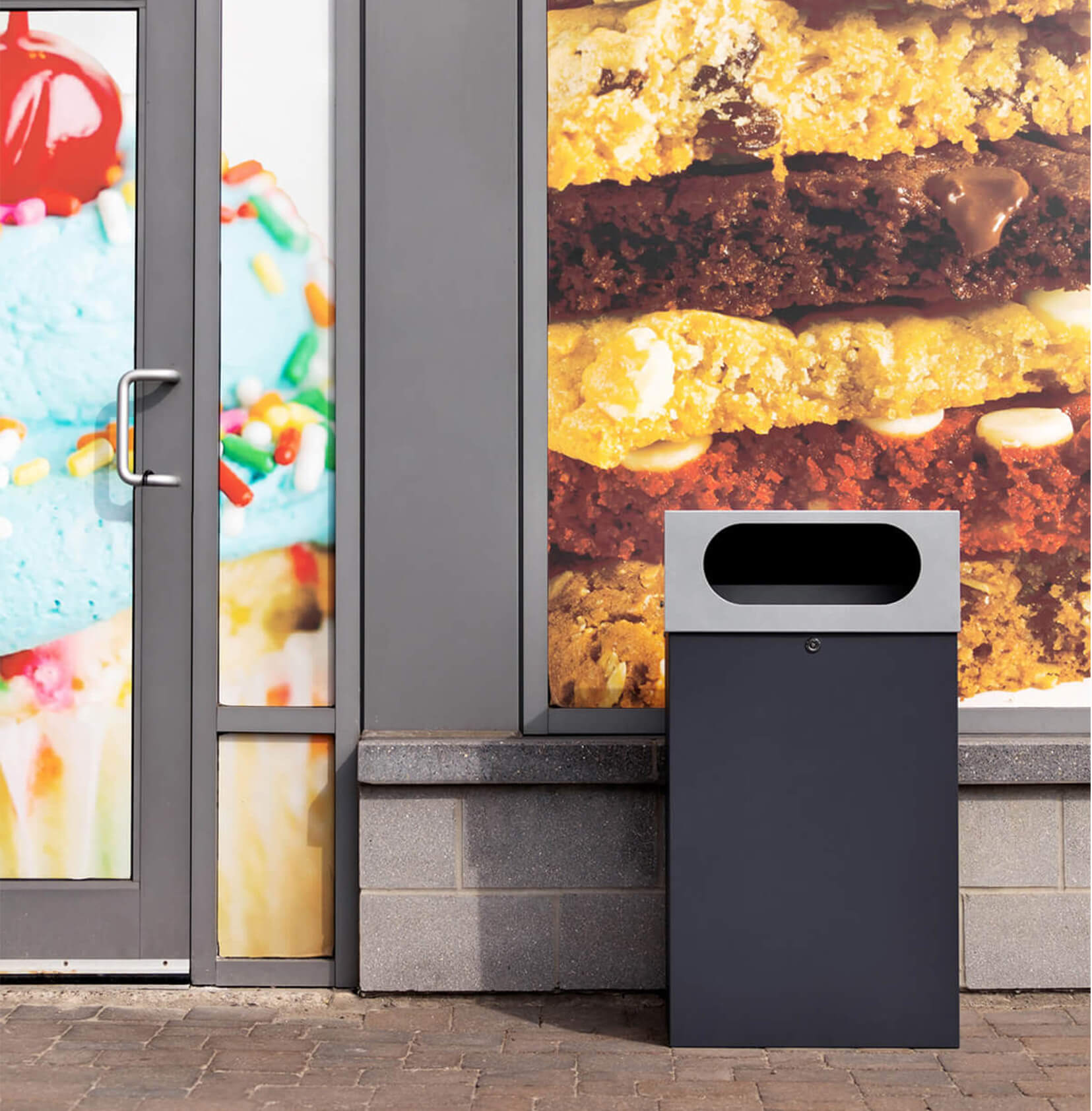 all metal powder coated outdoor waste bin with sloped lockable lid outside of a dessert restaurant