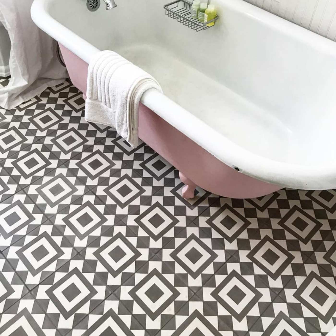 a bathroom with a pink and white bathtub and tiled floor.