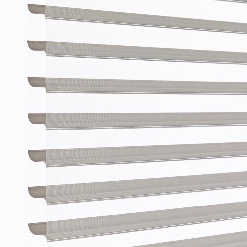 Zebra-style roller blinds, horizontal alternating sheer and opaque taupe stripes across a vertical window, aligned and partly open, filtering soft daylight against a bright white background in a close-up shot.