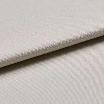 Beige woven fabric swatch folded diagonally, showing tight pebble-like texture; layered close-up under soft, neutral lighting, suggesting upholstery or curtain material.