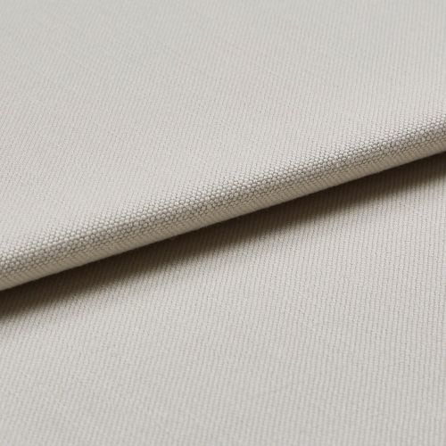 Beige woven fabric swatch folded diagonally, showing tight pebble-like texture; layered close-up under soft, neutral lighting, suggesting upholstery or curtain material.