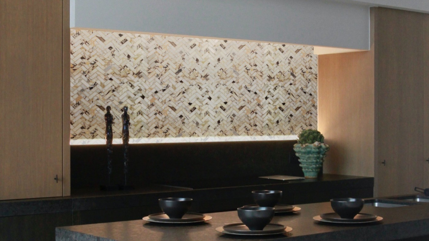 a kitchen with a black counter top and a tiled backsplash.