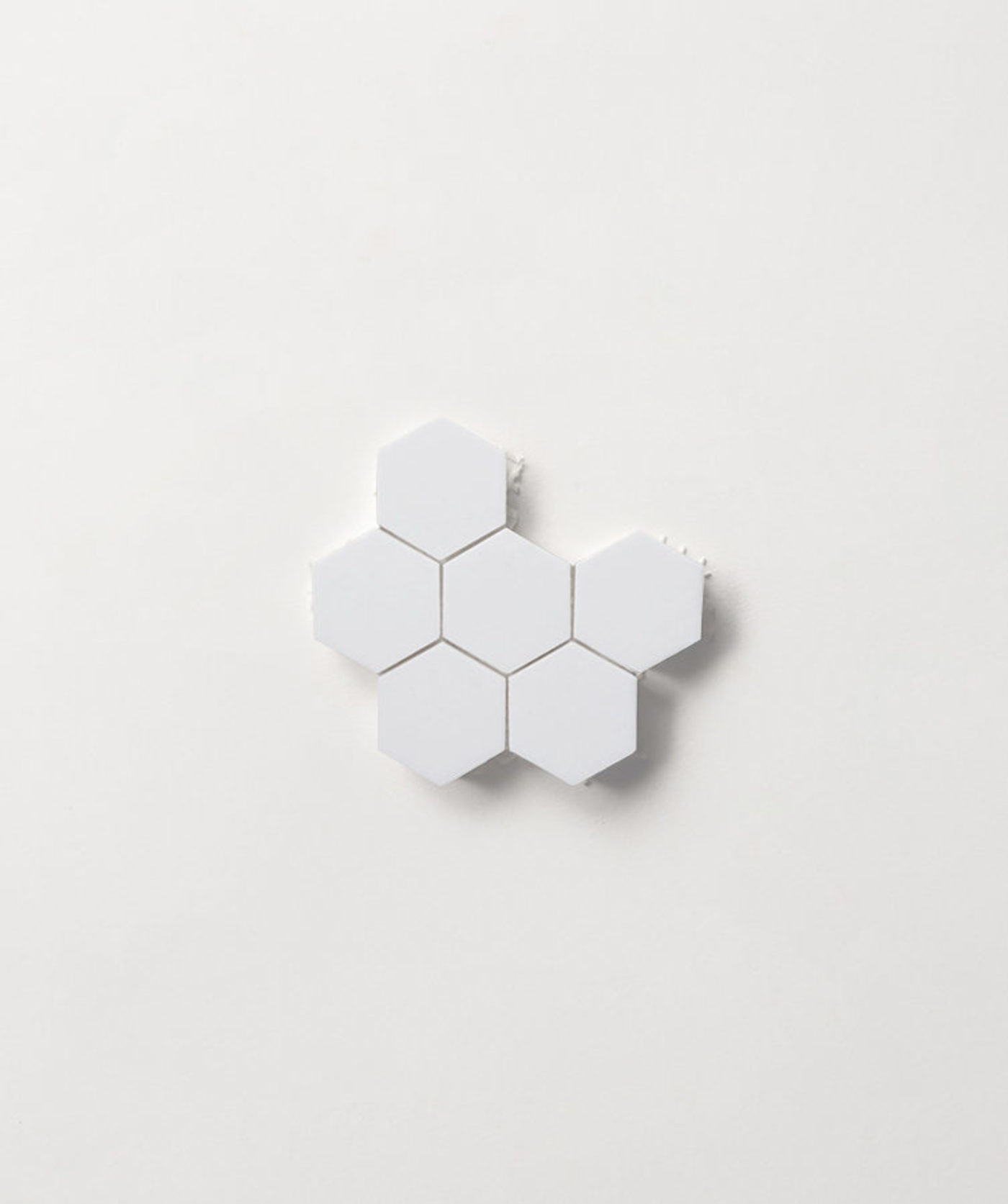 a sheet of small white hexagon tiles on a white background.