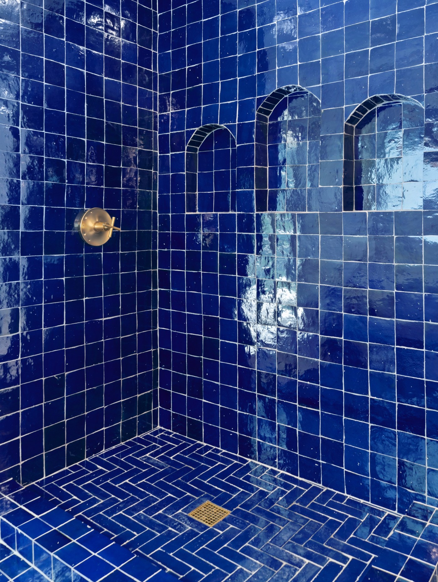 a blue tiled shower in a bathroom.