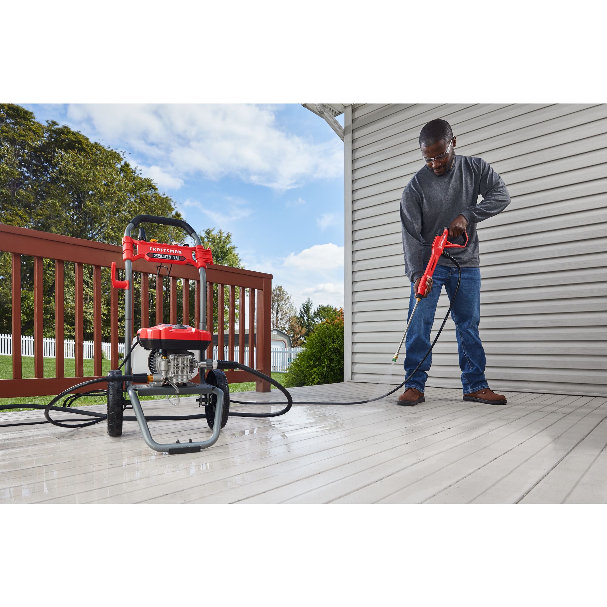 CRAFTSMAN 2800 Pressure Washer pressure washing outside deck with shed and trees in background