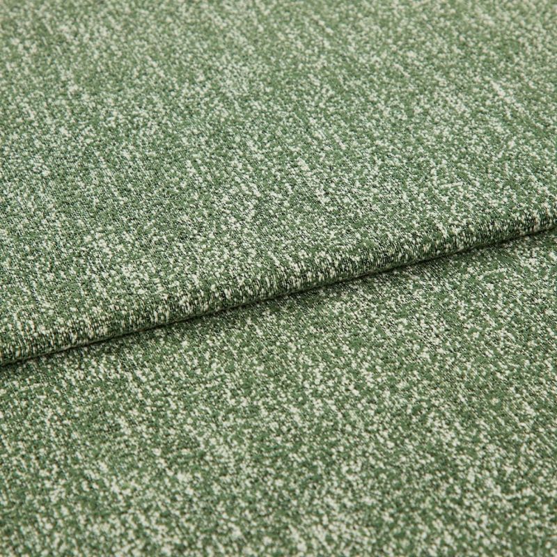 Folded green boucle upholstery fabric with white flecks, layered one fold over another; resting flat and revealing textured weave, photographed close-up under soft neutral studio lighting.