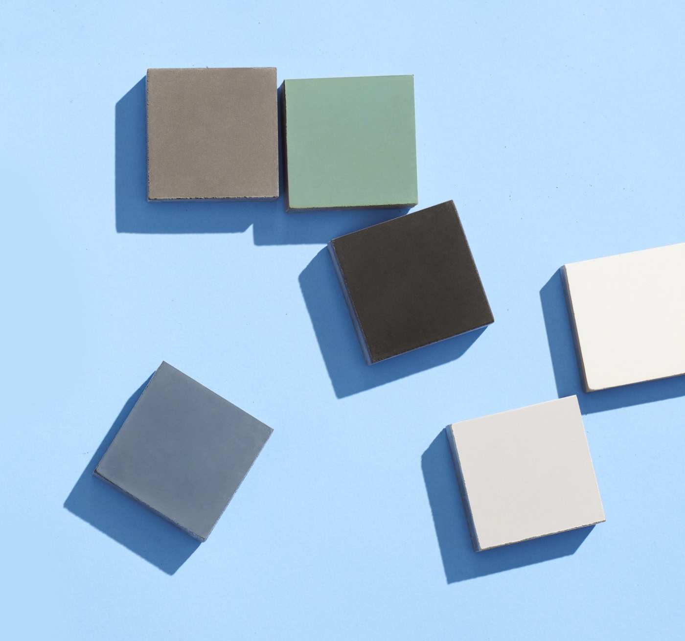 a group of different colored tiles scattered on a blue surface.