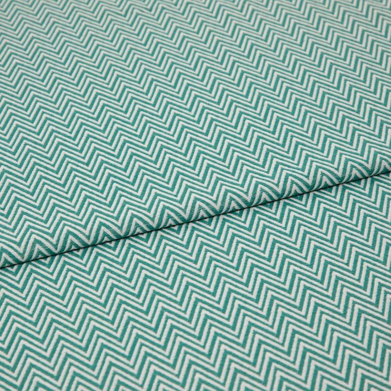 Folded teal-and-white chevron fabric (zigzag pattern) â€” folded once forming a horizontal seam â€” close-up, evenly lit textile filling the frame, showing texture and repeating geometric pattern.