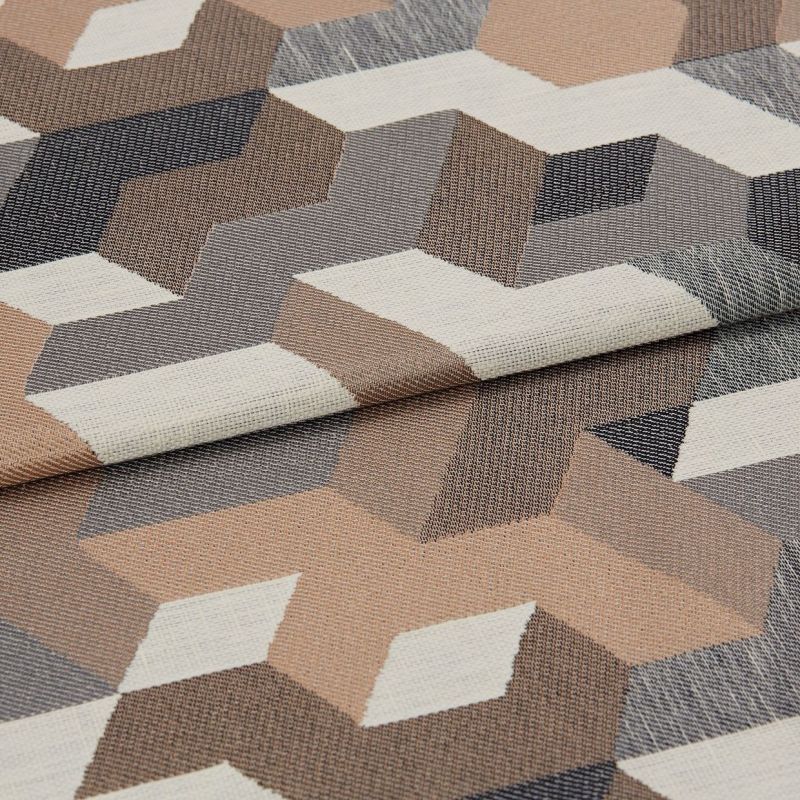 Woven fabric with folded edge, geometric 3D cube pattern in beige, gray, cream and brown; lying flat and slightly overlapped, close-up showing textured weave under soft, neutral lighting.