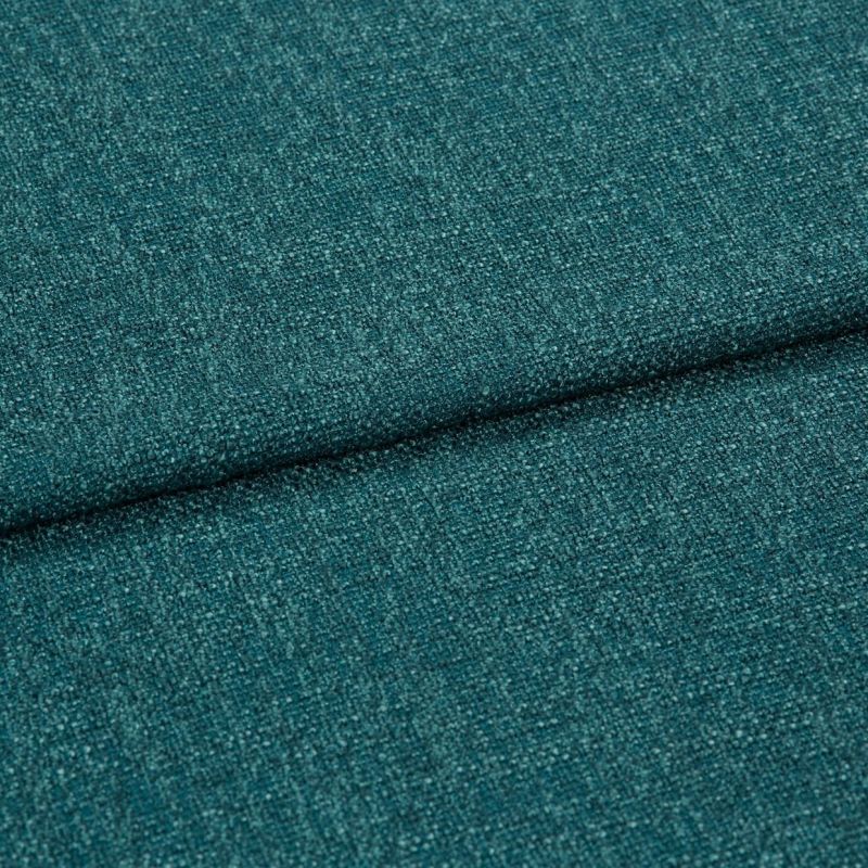 Teal woven upholstery fabric, close-up of a folded seam showing textured boucle-like weave; the fabric is folded diagonally across the frame, lit evenly in soft studio lighting.