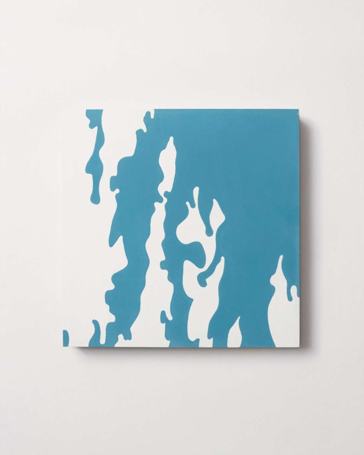 a blue and white tile on a white surface.