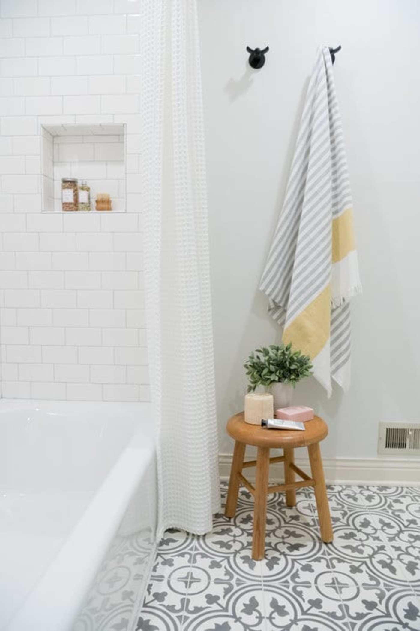 a bathroom with a stool and a black and white tile floor.