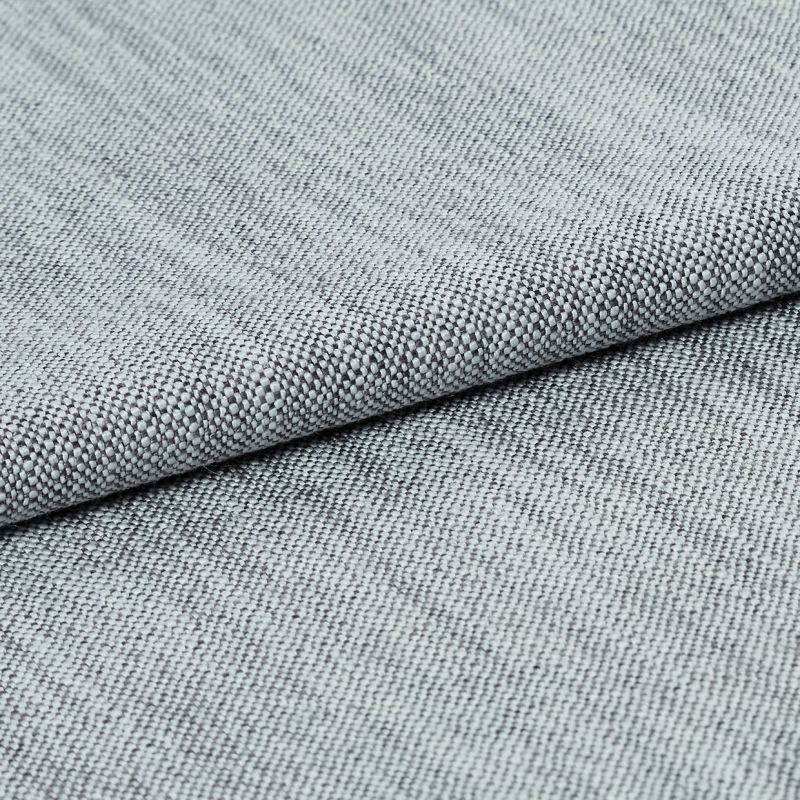 Light-gray tight basket-weave upholstery fabric, folded and layered to highlight its textured edge, photographed close-up under soft studio lighting on a neutral background.