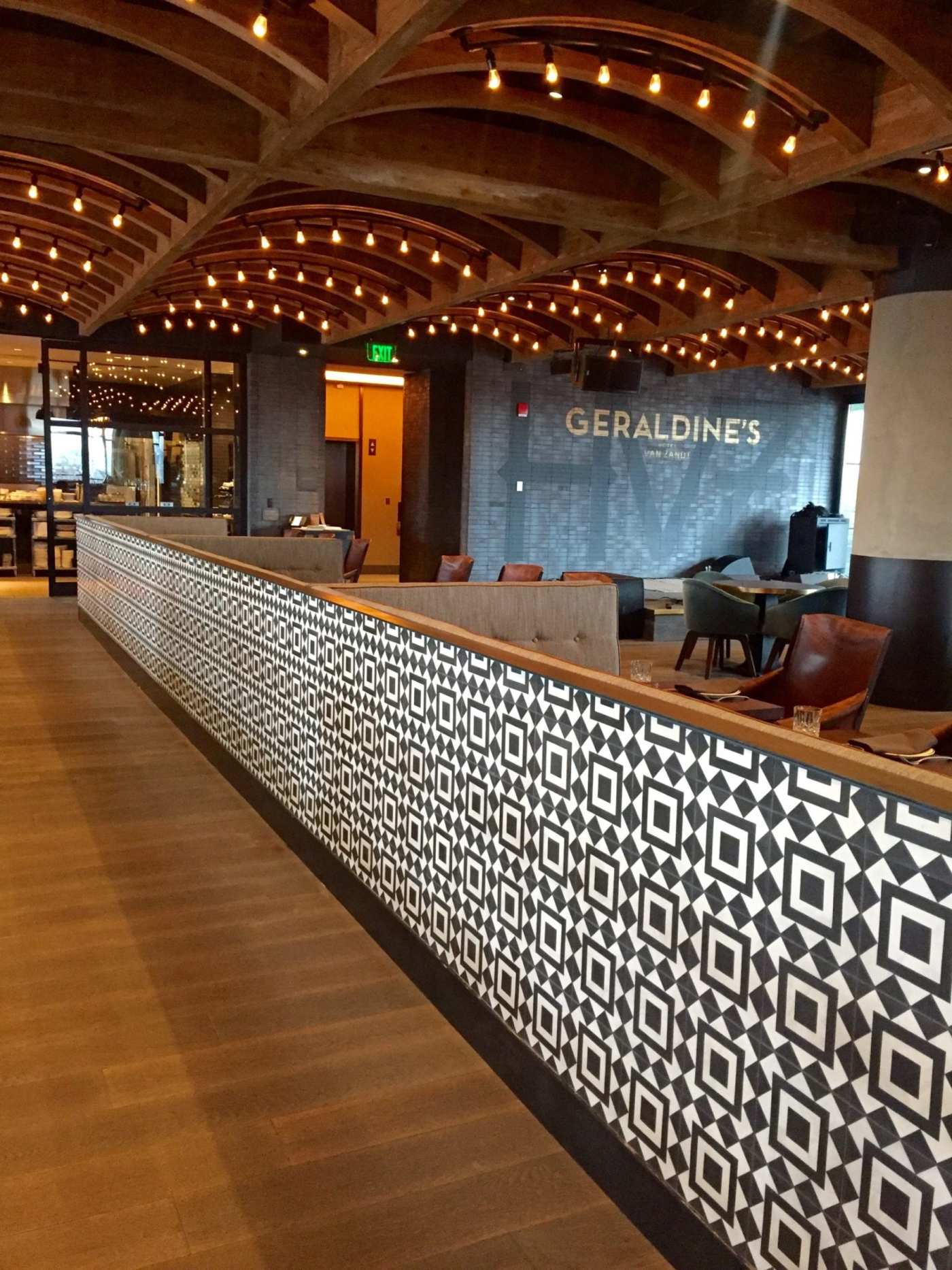 the lobby of a hotel decorated with black and white patterned tiles.