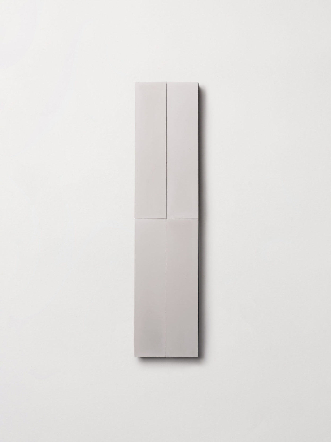 four grey rectangle tiles on a white surface.