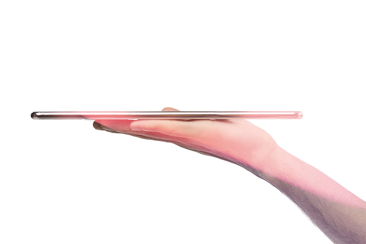 to demonstrate the slim and low profile a side angle shot shows a hand holding a light thinner than the width of the hand