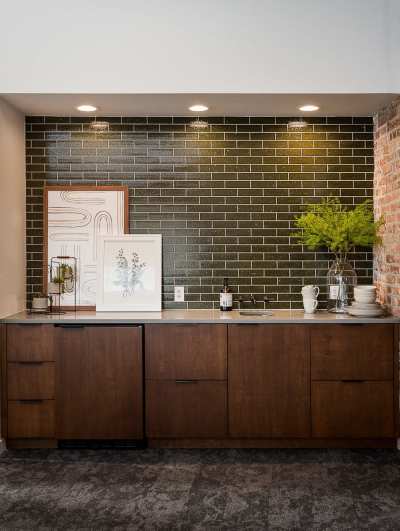 a kitchen with a brick wall and green tile.