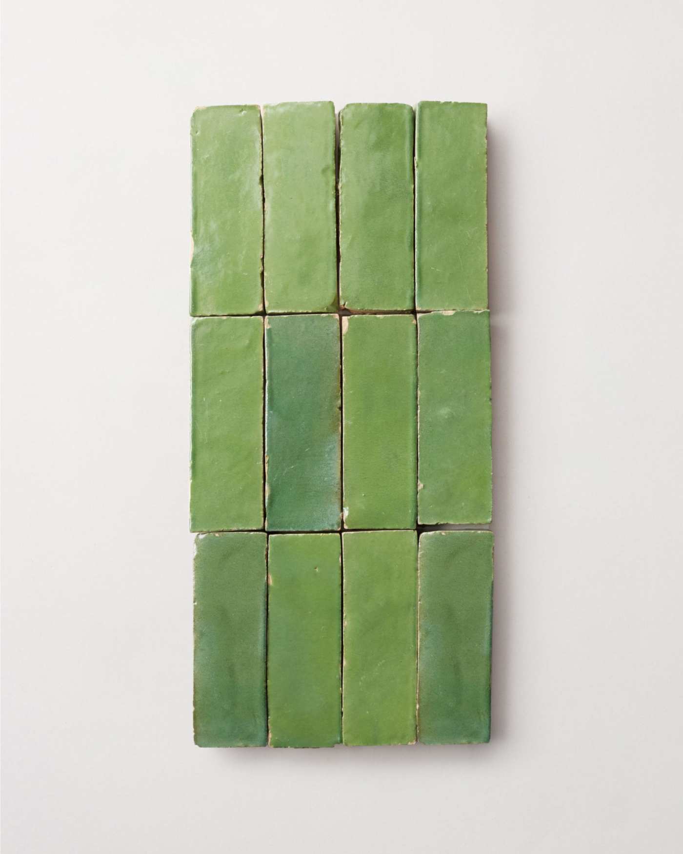 a group of green tiles on a white surface.